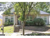 Inviting single-story home with brick facade, lush landscaping, and charming front porch at 6127 Landers Loop, Fairburn, GA 30213