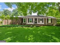 Charming brick home with a well-manicured lawn and inviting front porch at 2826 Summit Ridge Dr, Marietta, GA 30066