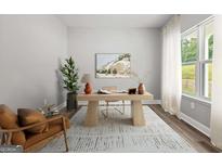 Bright office space featuring a wooden desk, decor, a plush rug, and a large window with sheer curtains at 5341 Stewart Mill Rd, Douglasville, GA 30135