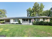 Charming home with a well-manicured lawn and an inviting covered porch, perfect for enjoying the outdoors at 2410 Thrasher Rd, Buford, GA 30519