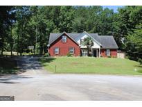 Charming brick home with well-manicured lawn and mature trees offering a serene suburban setting at 25 Castlehill Ct, Covington, GA 30016