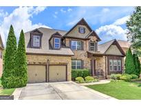 Beautiful two-story brick home featuring a two-car garage, lush landscaping, and a welcoming front entrance at 4924 Locklear Way, Marietta, GA 30066