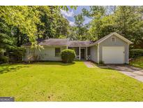 Charming one-story home with a well-manicured lawn and mature trees at 6200 Beaver Creek Trl, Atlanta, GA 30349
