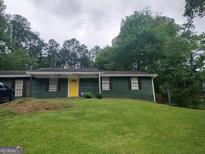 Charming single-story home with a bright yellow door and a well-maintained front lawn at 176 Avalon Way, Riverdale, GA 30274