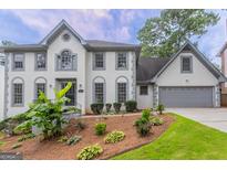 Charming two-story home with a well-manicured lawn and a two-car garage at 5674 Mountain Cres, Stone Mountain, GA 30087