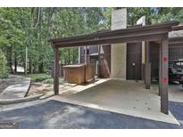 Attached carport featuring a brown painted wooden exterior and concrete floor providing covered parking at 36 Cobblestone Crk, Peachtree City, GA 30269
