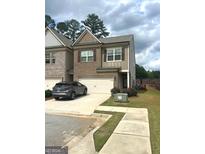 Charming two-story townhouse with brick and siding, a two-car garage, and a well-maintained front lawn at 2700 Norwich Trce, Snellville, GA 30078