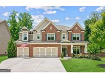 Beautiful brick and siding home with a three-car garage and well-manicured lawn at 4972 Park Vale Dr, Sugar Hill, GA 30518
