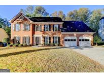 Two-story brick home with a two-car garage, black shutters, and a well-manicured lawn at 3034 Brookgreen Trl, Lawrenceville, GA 30043