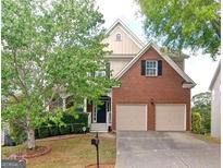 Two-story home with brick and siding, mature landscaping, and a two-car attached garage at 4518 Columbus Cir, Acworth, GA 30101