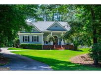 Charming single-story home with manicured lawn, mature trees, and a welcoming front porch at 7003 Tara Dr, Villa Rica, GA 30180