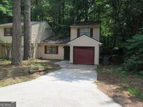 Charming home featuring a convenient one-car garage and a welcoming, extended driveway at 101 Pinetree Trl, Atlanta, GA 30349