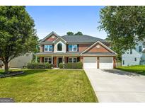 Beautiful two-story brick home with a well-manicured lawn and a two-car garage at 1209 Polk Xing, Mcdonough, GA 30252