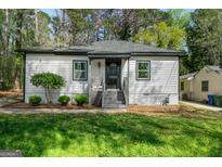 Charming single-story home featuring a well-manicured lawn and gray siding with a black roof at 437 Collier Ridge Nw Dr, Atlanta, GA 30318
