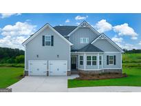 Charming two-story home featuring a two-car garage, landscaped front yard, and a mix of siding textures at 13709 Whitman Ln, Covington, GA 30014