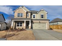 Charming two-story home featuring a two-car garage, stone accents and a well-maintained lawn at 504 Clayborne Way # 248A, Loganville, GA 30052