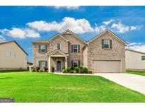 Beautiful two-story brick home with a well-manicured lawn on a sunny day at 209 Osier Dr, Mcdonough, GA 30252