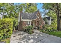 Charming brick Tudor-style home with lush landscaping and a welcoming driveway at 1718 Ridgewood Ne Dr, Atlanta, GA 30307