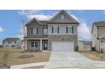 Charming two-story home with brick and siding exterior, attached two-car garage, and landscaped yard at 402 Westmarch Cir # 285A, Loganville, GA 30052