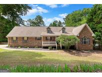 Charming brick home with dormer windows, mature trees, and a well-maintained front lawn at 116 Alexander Dr, Mcdonough, GA 30252