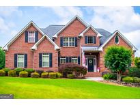 Beautiful brick home featuring a well-manicured lawn and lush landscaping at 713 Birkdale Blvd, Carrollton, GA 30116