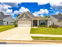 Charming single-story home featuring a well-maintained lawn and an attached two-car garage at 326 Elkins Place, Peachtree City, GA 30269