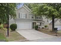 Charming two-story home features a two-car garage and a well-manicured front lawn at 3347 Sable Glen, Atlanta, GA 30349