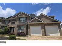 Two-story brick home featuring a two-car garage, well-maintained landscaping, and a classic architectural design at 215 Gunnison Sw Pl, South Fulton, GA 30331