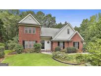 Charming two-story brick home with a manicured lawn and mature landscaping at 128 Rubicon Rd, Peachtree City, GA 30269