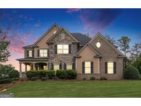 Beautiful two-story home with a well manicured lawn and a combination of stone and brick facade at 4830 Northridge Dr, Cumming, GA 30041