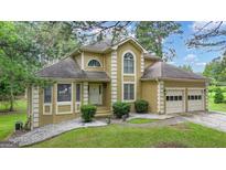 Charming two-story home with attached two-car garage and well-maintained landscaping at 115 Rockhurst Chase, Tyrone, GA 30290