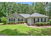 Charming single-story home with a well-manicured lawn and lush landscaping at 40 Riverside Pkwy, Sharpsburg, GA 30277
