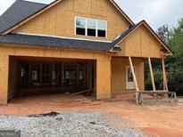 Unfinished exterior elevation showing the frame of the home, garage and door under construction at 333 Brookstone Dr, Carrollton, GA 30116