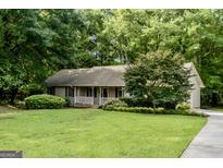 Charming single-story home with a well-maintained lawn and mature trees at 1624 Hampton Locust Grove Rd, Locust Grove, GA 30248