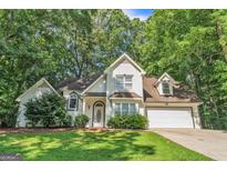 Charming two-story home featuring a well-manicured lawn and lush trees at 105 Rosewood Cir, Covington, GA 30016