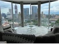 Bright living room with floor-to-ceiling windows showcasing a stunning city skyline view at 285 Centennial Olympic Park Drive Northwest Nw Dr # 1905, Atlanta, GA 30339