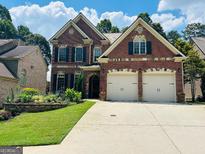 Beautiful two-story brick home with a two-car garage and well-manicured lawn at 705 Lawton Bridge Sw Rd, Smyrna, GA 30082