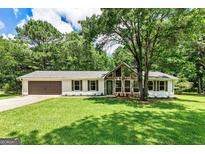 Charming single-story home featuring stone accents, a well-manicured lawn, and mature trees offering ample shade at 125 Selena Ct, Fayetteville, GA 30215