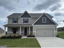 Charming two-story home with gray siding, a two-car garage, and a well-manicured lawn at 676 Cantrell Drive, Dallas, GA 30157
