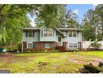 Charming two-story home with light blue siding, brick accents, and a lush green lawn at 201 Greensprings Dr, Palmetto, GA 30268