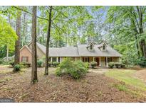 Charming home boasts a welcoming front porch, dormer windows, and a blend of brick and siding at 215 Longwood Dr, Jonesboro, GA 30236