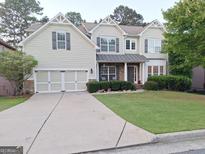 Charming two-story home with a well-manicured lawn, neutral siding, and a two-car garage at 522 Blue Mountain Rise, Canton, GA 30114