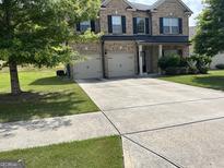 Beautiful two-story brick home with a spacious driveway and a well-manicured front yard at 8109 Nolan Trl, Snellville, GA 30039