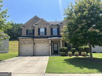 Charming two-story brick home featuring a two-car garage, well-manicured lawn, and inviting front entrance at 8109 Nolan Trl, Snellville, GA 30039