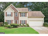 Two-story home featuring a brick facade, neutral siding, manicured lawn, and two car garage at 2580 Star Ln, Decatur, GA 30034