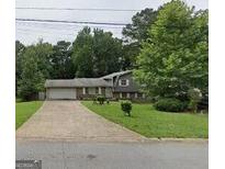 Charming single-Gathering home with attached garage and well-maintained front yard at 7313 Grayson Dr, Riverdale, GA 30296