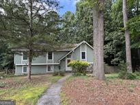 Charming home featuring a well-maintained lawn, mature trees, and inviting walkway at 6875 Timberclair Ct, Lithonia, GA 30058