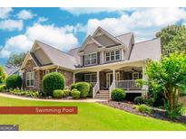 Charming two-story home with a stone facade, covered porch, manicured lawn, and lush landscaping at 53 Denny Ln, Dallas, GA 30157