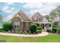 Charming two-story home showcasing a blend of stone and siding, complemented by a well-manicured lawn and landscaping at 53 Denny Ln, Dallas, GA 30157