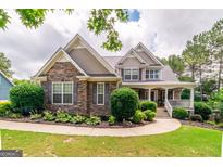 Charming two-story home with stone accents, manicured landscaping, and inviting front porch at 53 Denny Ln, Dallas, GA 30157